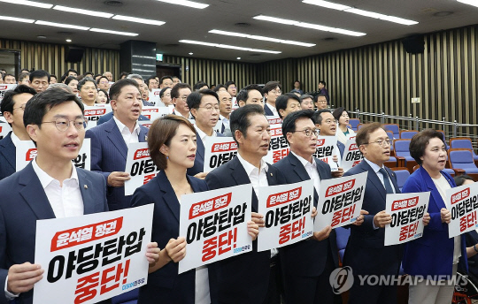 더불어민주당 의원들이 12일 국회에서 열린 의원총회에서 구호를 외치고 있다. 연합뉴스